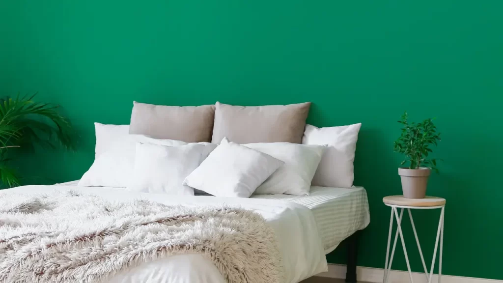 Quarto com paredes em verde musgo, tendência de cores de decoração para 2025.