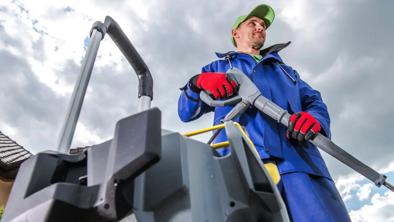 Close-up de uma pessoa limpando um telhado com uma lavadora de alta pressão antes de aplicar a tinta térmica.