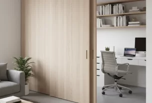 Parede deslizante de madeira clara em um ambiente pequeno e moderno, separando a área de estar de um escritório.
